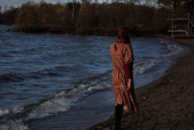 Rear view of woman standing on beach