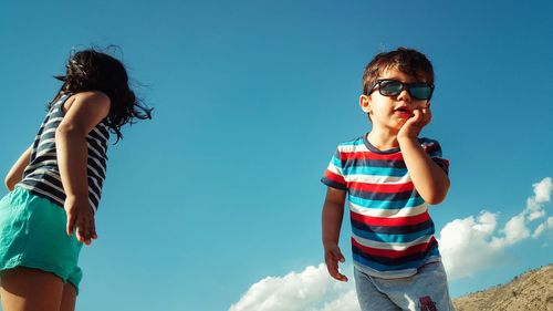 Low angle view of child against blue sky