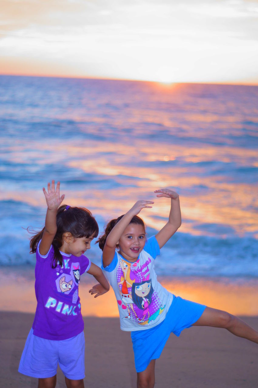 lifestyles, person, leisure activity, childhood, happiness, sky, smiling, casual clothing, elementary age, young adult, girls, young women, looking at camera, sunset, enjoyment, sea, portrait, vacations