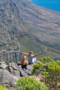 Woman sitting on rock looking at mountain