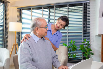 Side view of man using mobile phone while sitting at home