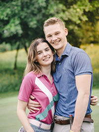 Portrait of smiling young couple standing in park