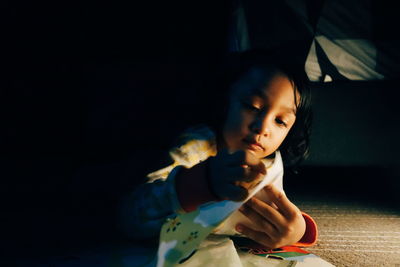 Close-up of innocent girl reading book at home