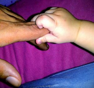 Close-up of cropped hand holding baby