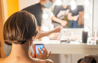 Rear view of woman using mobile phone