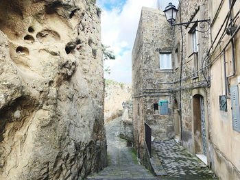 Narrow alley amidst buildings against sky