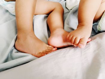 Low section of man relaxing on bed