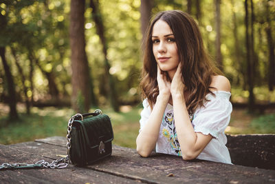 Portrait of beautiful young woman sitting outdoors