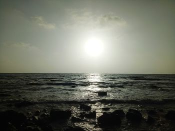 Scenic view of sea against bright sun