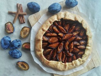 High angle view of pie and plums on table