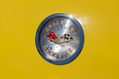 Close-up of telephone booth against yellow wall