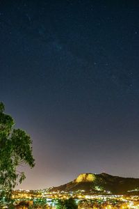 Low angle view of illuminated trees against sky at night