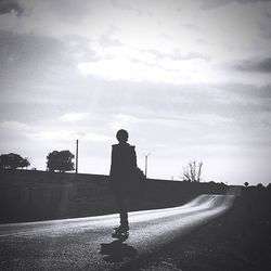 Rear view of silhouette man against road