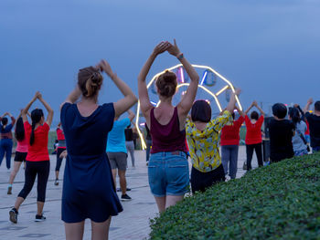 Rear view of people standing against clear sky