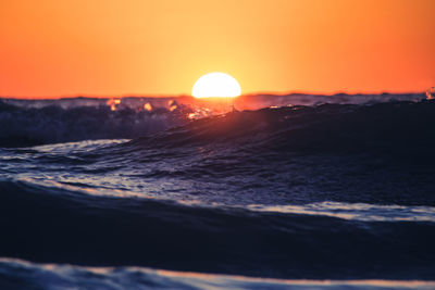 Scenic view of sea against orange sky