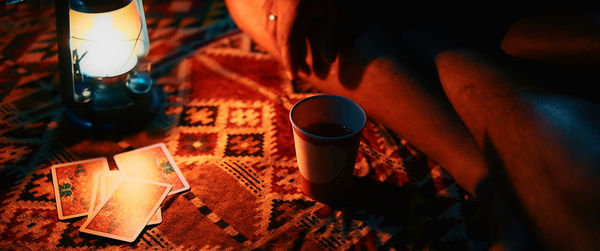 People playing cards at night near the campfire.