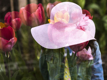 Close-up of pink hat on flower against woman