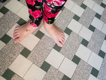 Low section of woman standing on tiled floor