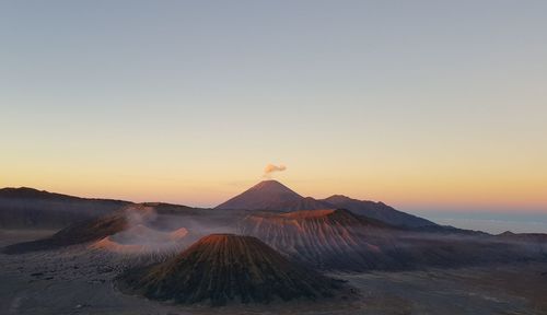 Scenic view of volcanic mountains against sky during sunrise