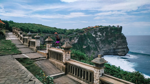 Built structure in sea against cloudy sky