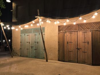 Illuminated lights hanging at entrance of building at night