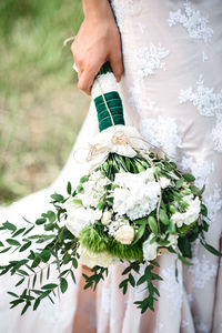 Midsection of woman holding flower bouquet