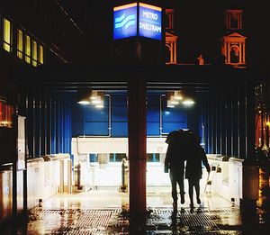 Man walking in illuminated city at night