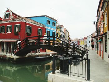 View of canal in city against sky