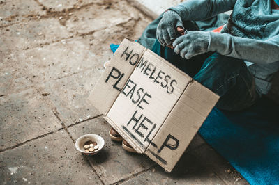 Low section of homeless man sitting on street