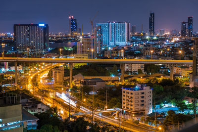 Illuminated buildings in city against sky at night