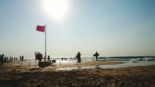 People on beach against clear sky