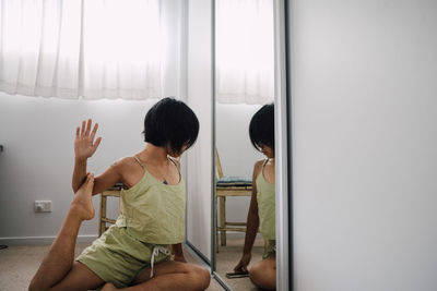 Rear view of woman looking through window