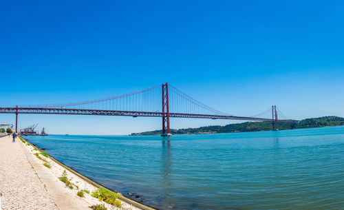 View of suspension bridge against clear blue sky