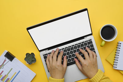 Cropped hands using laptop on table