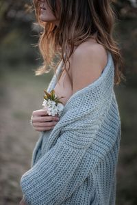 Midsection of woman standing by flowering plant