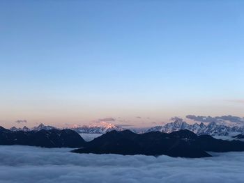 Scenic view of snowcapped mountains against clear sky during sunset