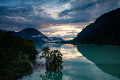 Scenic view of lake and mountains against sky during sunset