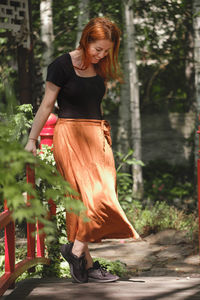 Happy ginger hair woman walking barefoot in the park or garden. freedom and healthy way of life