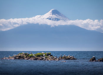 Scenic view of sea and mountains against sky