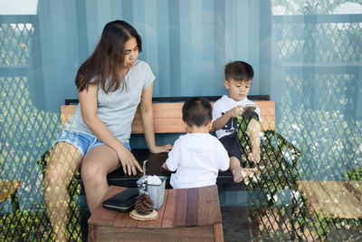 Mother with sons in cafe seen through window