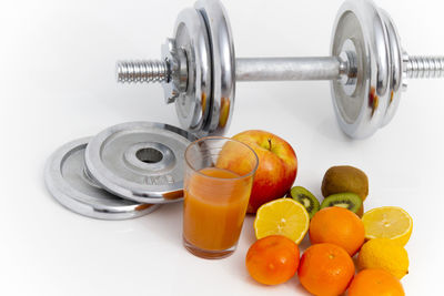 Close-up of oranges in container against white background