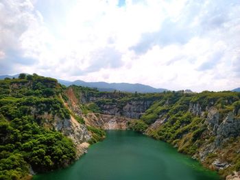 Scenic view of river amidst mountains against sky