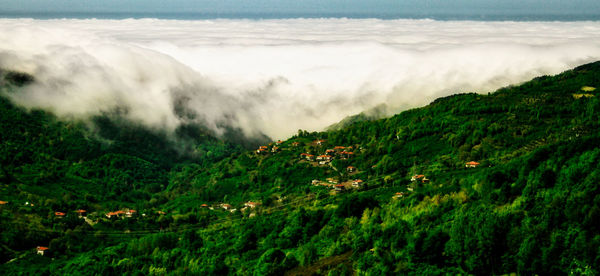 Scenic view of land and sea against mountains