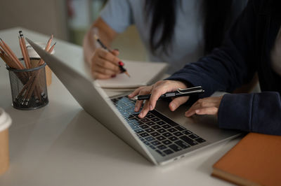 Midsection of man using laptop on table