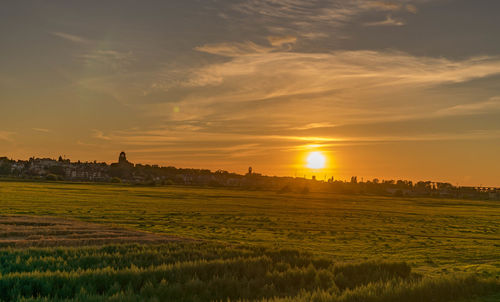 Scenic view of field against sky during sunset