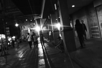 Full length of woman walking on illuminated street at night