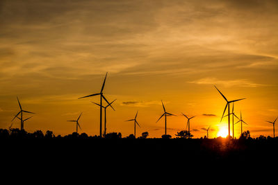 Silhouette of wind turbines during sunset