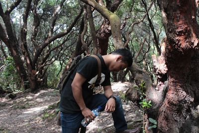 Side view of young man in forest