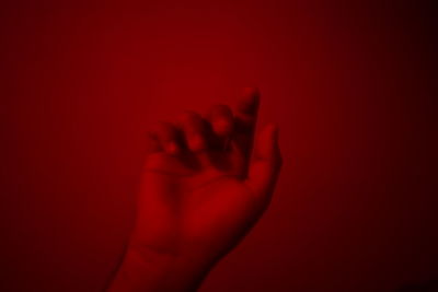 Close-up of human hand against red background