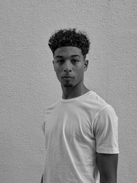 Portrait of young man standing against wall